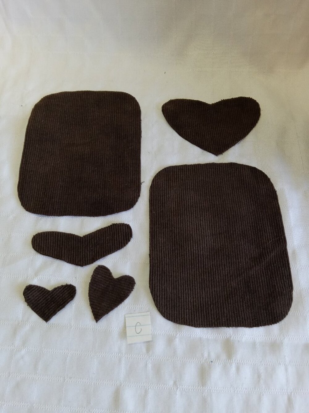 Two handmade elbow patches for sewing made of brown corduroy with hearts